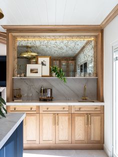 a kitchen with marble counter tops and wooden cabinets, along with potted plants in the corner