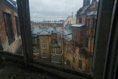 the view from inside an old building looking out at rooftops and buildings in the distance