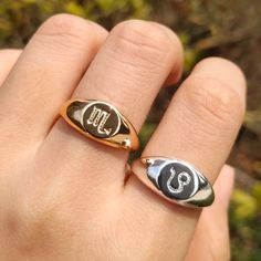 a person's hand with two rings on it and one has the letter c