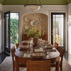 the dining room table is set with plates and place settings for four people to eat