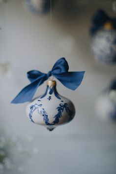 a blue and white ornament hanging from a string with a bow on it