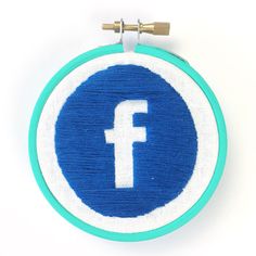 a blue and white embroidered circle with the letter f in it's center on a white background