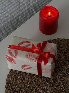 a wrapped present sitting next to a lit candle