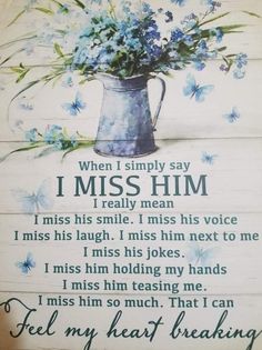 a sign that says i miss him with blue flowers in a watering can