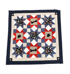 a red, white and blue patchwork quilt with dogs on it's sides