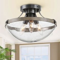 a semi flush ceiling light with three bulbs on the top and two lights in the middle