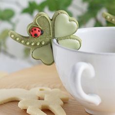 there is a cookie shaped like a ladybug sitting on top of a cup