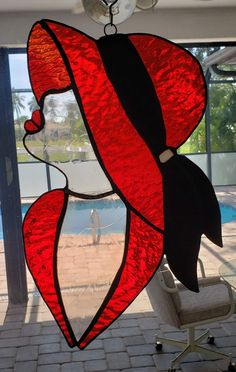 a stained glass window with a woman's face in red and black on it