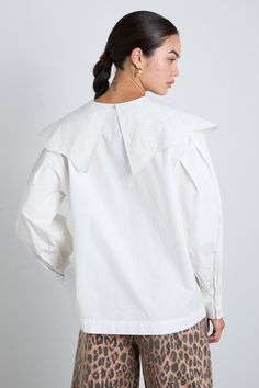 The Romeo is a hip length shirt with full, cuffed sleeves and a rounded neckline. It features an oversized wave edge collar with "DM" Damson Madder broderie detailing along the collar edge and arm. •100% Organic Cotton •Oversized collar •White embroidery detailing •We recommend sizing down for a neater fit MODEL INFO: Sofie is 5'10 and is wearing a UK 10. White Tops With Embroidered Cuffs For Workwear, Chic Long Sleeve Tops With Embroidered Cuffs, Crochet Hair Bows, Damson Madder, Rose Quilt, Canvas Makeup Bag, Quilted Backpack, Embroidery Detailing, Oversized Collar