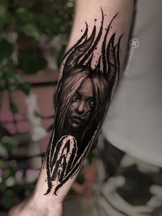 a man's arm with a black and white tattoo design on the left forearm