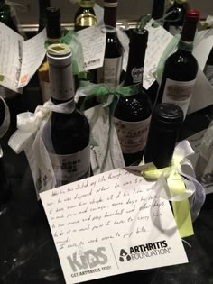 a bunch of wine bottles sitting on top of a table next to a note with writing