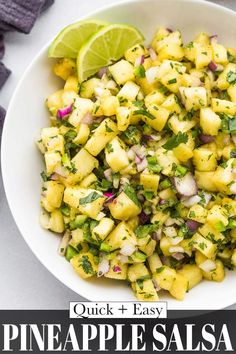 pineapple salsa in a white bowl with limes and cilantro on the side