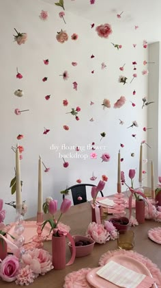 the table is set with pink flowers and candles