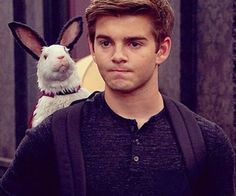 a man standing next to a white bunny