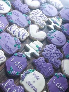 purple and white decorated cookies on a wooden table with the words i love you in cursive writing