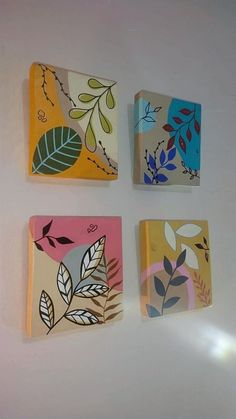 four square tiles with leaves painted on them