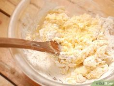 a wooden spoon mixing batter in a glass bowl