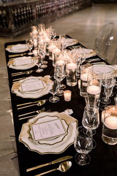 a long table is set with candles and place settings