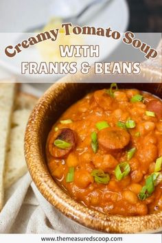 creamy tomato soup with franks and beans in a brown bowl on a white napkin next to some pita bread