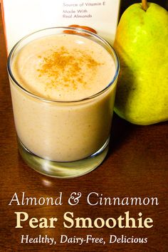 there is a glass of pear smoothie next to an apple and a book on the table