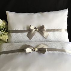 two white pillows with satin bows on them