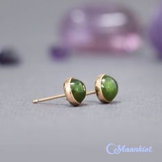 These Natural Jade Stud Earrings feature lovely 6 mm green jade cabochons. These matched green stones are carefully set in gold filled bezels here in our studio. These bezels are firmly soldered to posts and tumble polished for hours to a high shine. Jade has been used from prehistoric periods for hardstone carving. Material - gold filled post, gold filled bezel, 6 mm green jade cabochons, gold filled earring backs Dimensions - Cabochons measure 6 mm in diameter, Stud posts are 11 mm long in a 2 Green 14k Gold Earrings With Bezel Setting, Green Earrings With Bezel Setting For May Birthstone, Prehistoric Period, Small Stud Earrings, Green Stones, Small Earrings Studs, Gold Filled Earrings, Natural Jade, Green Jade