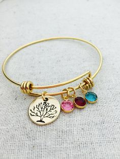 "This listing includes a gold plated stainless steel bangle bracelet. Bracelet includes a 5/8\" nu gold, brass disc hand stamped with tree and gold plated Swarovski birthstone crystal charms. PLEASE INCLUDE IN THE NOTE TO SELLER SECTION AT CHECKOUT THE BIRTHSTONES NEEDED IN THE ORDER YOU WOULD LIKE THEM ON THE BANGLE. Nu-gold is a copper alloy consisting of 85% copper and 15% zinc. It has a rich warm color and if highly polished resembles gold. This is also known as jewelers brass and will tarni Gold Charm Bracelet With Birthstone For Anniversary, Nickel-free Gold Bangle Charm Bracelet, Gold Nickel-free Bangle Charm Bracelet, Gold Bangle With Birthstone For Gift, Gold Birthstone Bracelet For Mother's Day, Gold Bangle With Birthstone As Gift, Gold Nickel-free Bangle As Gift, Gold Round Bracelet With Birthstone, Gold Bangle With Birthstone