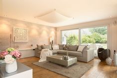 a living room filled with lots of furniture and flowers on top of a wooden floor