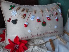 a decorative pillow with clothes pins and poinsettis attached to it on a bed