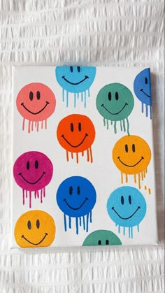 a canvas with different colored smiley faces on it