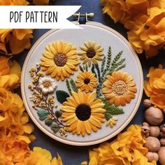 an embroidery pattern with sunflowers and leaves on the hoop surrounded by yellow flowers