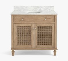 a bathroom vanity with a white marble top and wooden handles on the doors, side view