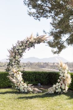 a wedding arch decorated with flowers and feathers