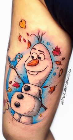 a cartoon tattoo on the leg of a woman's thigh with an image of snowman and bird