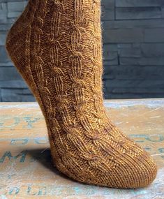 a person's feet with socks made out of knitted yarn on top of a table