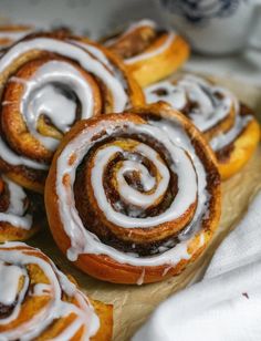 cinnamon buns with icing on a wooden cutting board