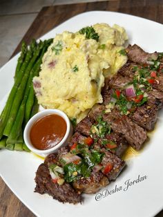 steak, mashed potatoes and asparagus on a white plate with ketchup