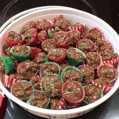 a bowl filled with cupcakes covered in chocolate frosting and sprinkles