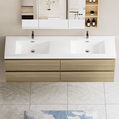 a bathroom with two sinks and mirrors on the wall next to a rug in front of it