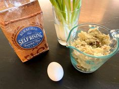 an egg and some rice on a table next to a bag of seaweed rising