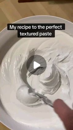 a person is mixing white cream in a bowl