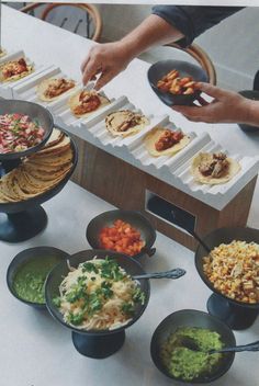 a table topped with lots of food and bowls filled with different types of toppings