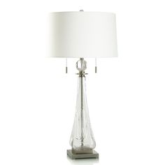 a glass table lamp with a white shade