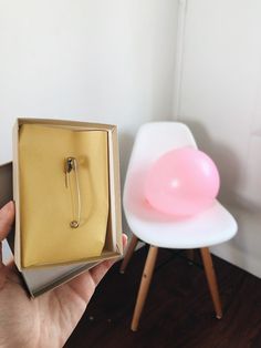 a person holding an open box with a pink object in the corner next to it