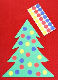 a christmas tree made out of construction paper with a polka dot sticker on top