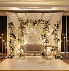 a wedding stage decorated with white flowers and greenery for an event or function venue