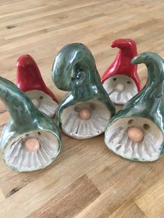 four ceramic figurines sitting on top of a wooden floor