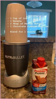 a blender sitting on top of a counter next to a bottle of nut butter