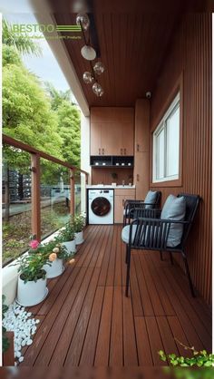 a wooden porch with potted plants and a chair on the front deck, next to a washing machine