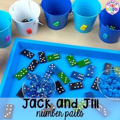 a blue tray filled with lots of dices next to buckets and plastic cups